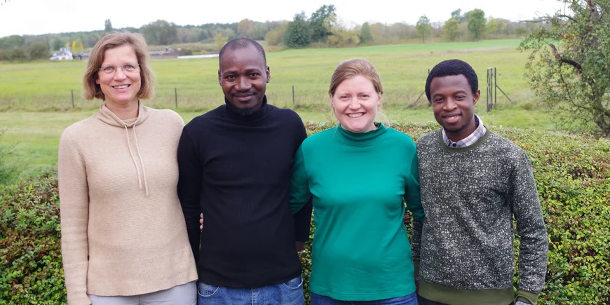 Four GreenGaDe members from Potsdam standing in front of a meadow