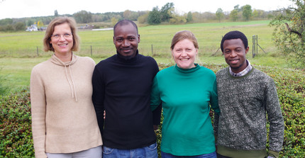 Four GreenGaDe members from Potsdam standing in front of a meadow