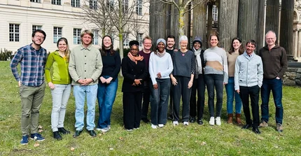 Group of scientists posing in front of columns of historical building