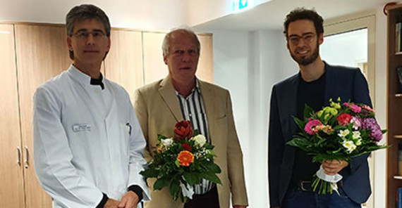 Der Vorsitzende des Promotionsausschusses Prof. Dr. Heinz Völler (links) und Doktorvater Prof. Dr. Martin Heinze (Mitte) gratulieren Dr. Samuel Thoma zum erfolgreichen Abschluss. Das Foto ist von MHB/K. Toptschian.