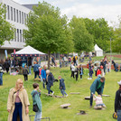 Viele Kinder mit Spielgeräten auf einer Wiese.