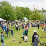 Viele Kinder mit Spielgeräten auf einer Wiese.