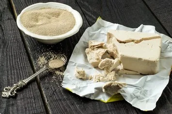 Schale mit Trockenhefe und frische Hefe zerbröckelt