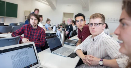 Masterclass mehere Personen an Laptops sind in eine Diskussion vertieft