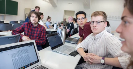 Masterclass mehere Personen an Laptops sind in eine Diskussion vertieft