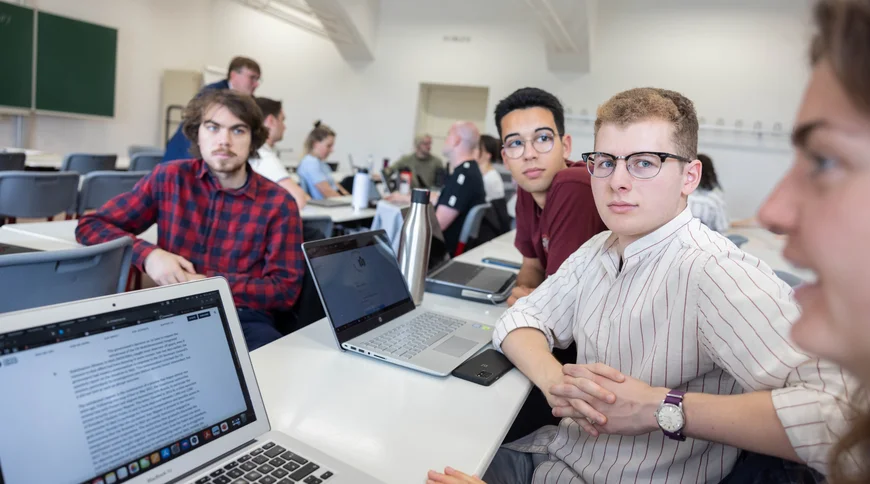 Masterclass mehere Personen an Laptops sind in eine Diskussion vertieft