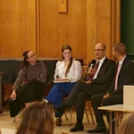 Auf dem Bild sieht man die Teilnehmer diskutieren. Prof. Dr. Sonnentag hat das Mikrofon in der Hand.