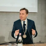 Ein Mann im Anzug mit einer Amtskette an einem Rednerpult