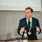 Ein Mann im Anzug mit einer Amtskette an einem Rednerpult