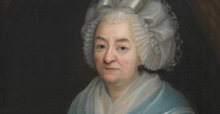 Porträt einer älteren Frau in hellblauem Kleid und feinem Spitzenhäubchen.