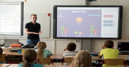 Lehrer vor Klasse am Smartboards