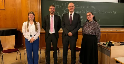 Auf dem Bild sieht man die vier Teilnehmer der Podiumsdiskussion nebeneinander aufgestellt.