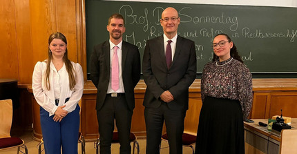Auf dem Bild sieht man die vier Teilnehmer der Podiumsdiskussion nebeneinander aufgestellt.