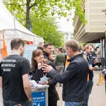 Mehrere Personen stehen vor einem Zelt