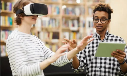Frau mit VR-Brille und Mann mit Buch in der Hand