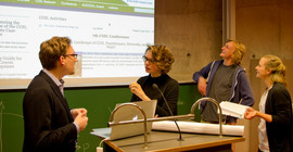 Alexander Knoth (l.) diskutiert mit studierenden seines Seminars über studentische Onlineartikel zu gesellschaftspolitischen Themen. Foto: Leo Peters