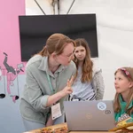 Eine Frau erklärt einem Kind etwas am Laptop