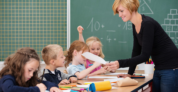 Lehrerin steht vor einer Klasse Grundschülern.