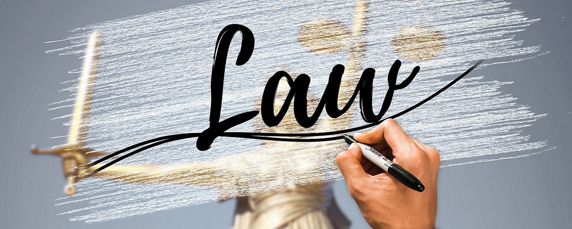 Migration Law Ahand writes “Law” - in the background the Justizia -