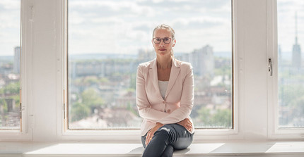 Prof. Dr. Frauke Brosius-Gersdorf im Porträt auf einer Fensterbank sitzend.