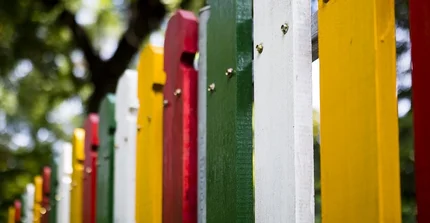 Ein bunt angestrichener Holz-Zaun.