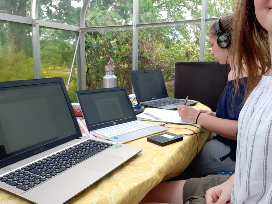 Mensch mit Mensch mit drei Laptops in Wintergarten