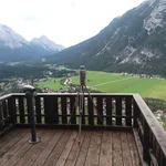 Field site Leutasch: Laser scanner on a tripod setup on a viewing platform overlooking a flat valleybottom surrounded by high, forested mountains | Photo: Cosmic Sense Consortium