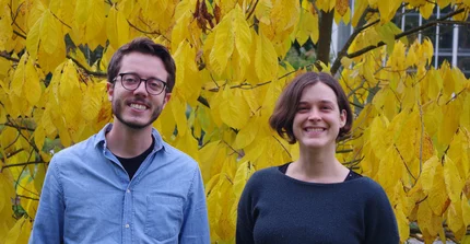 Portrait picture of Thomas Bringhenti and Ildikó Orbán in front of a tree with yellow leaves