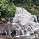 Wasserfall bei Ubud. Der sichtbare Ausschnitt stürzt aus fast 10m Höhe über Felstreppen in ein Flussbett.