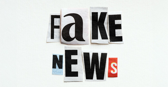 The words “fake news” are laid out on a white background using letters cut out from newspaper articles.