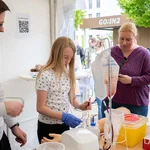 Ein Kind und Erwachsene stehen an einem Tisch mit medizinischem Equipment.