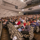 Viele Personen im Zuschauerraum eines Konzertsaals