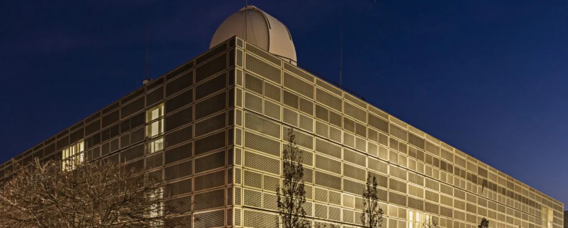 Dreistöckiges goldenes Gebäude mit Übungsobservatorium bei Nacht