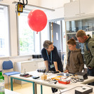 4 Personen stehen an einem Tisch mit technischen Geräten