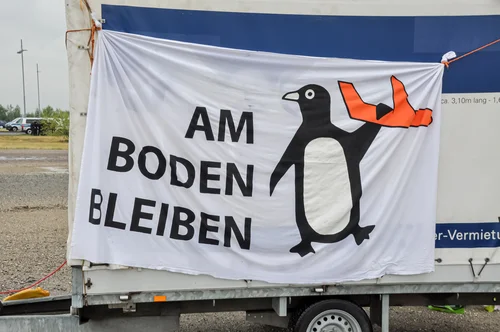 A banner with a big penguin holding a plane