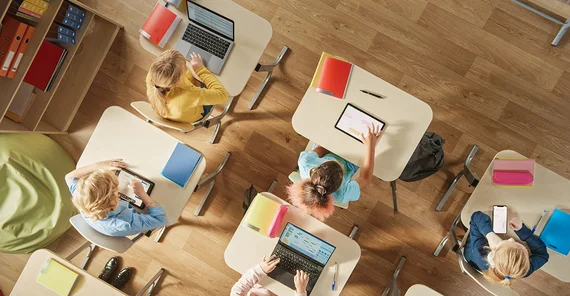 Blick von oben auf Schülerinnen und Schüler in einem Klassenraum