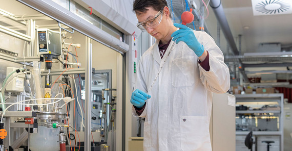 While the chemicals are pumped into the reactor, Koenig takes a sample from the mixed solution every five minutes using a glass pipette. These samples are used for another method in the adjacent lab: dynamic light scattering to measure particle size distribution.