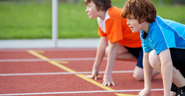 Zwei Jungen in Startposition für einen Lauf.