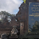 Tafel mit traditioneller Schrift am Pura-Luhur-Batukau-Tempel. Der Hintergrund der Tafel ist schwarz glänzend, die Schrift goldfarben.