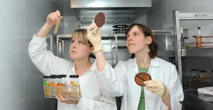 Studierende im weißen Laborkittel im Labor