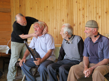 Scherbaum beim Anlegen eines Spezialmikrofons bei Givi Pirtskhelani. Außerdem im Bild die Sänger Gigo Chamgeliani und Murad Pirtskhelani 