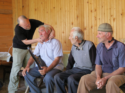 Frank Scherbaum installing special microphones on Givi Pirtskhelani. Also on the photo: the singers Gigo Chamgeliani, Murad Pirtskhelani - during the experiments in Lakhushdi/Swanetia