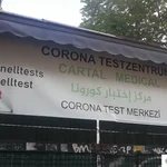 22- Banner eines Corona-Testzentrums in Berlin, Neukölln (Deutsch, Arabisch, Türkisch).