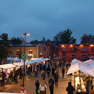 Marktstände auf einem Platz, Ziegelgebäude im Hintergrund