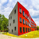 Ein rotes Gebäude, das eine wellenförmig geschwungene Fassade hat