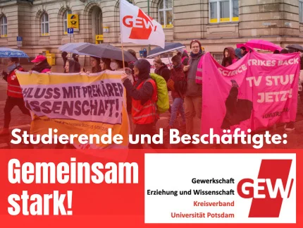 Personen mit Transparenten, darauf ein roter Balken mit weißer Schrift "Gemeinsam stark"