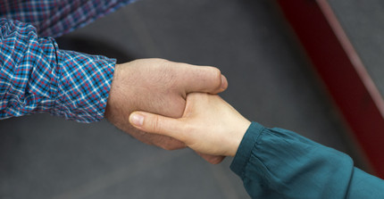 Mann und Frau reichen sich die Hand