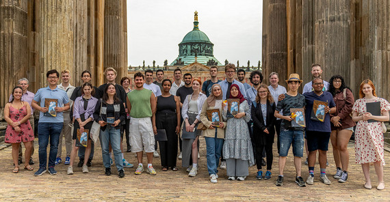 Gruppenfoto der Absolventinnen und Absolventen der Studienvorbereitung Brandenburg (SVB) 2022/23 vor den Kolonnaden am Neuen Palais.