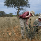 Zwei Forschende führen wissenschaftliche Messungen in der afrikanischen Savanne durch