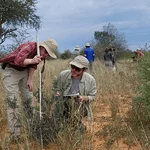 Zwei Forschende führen wissenschaftliche Messungen in der afrikanischen Savanne durch